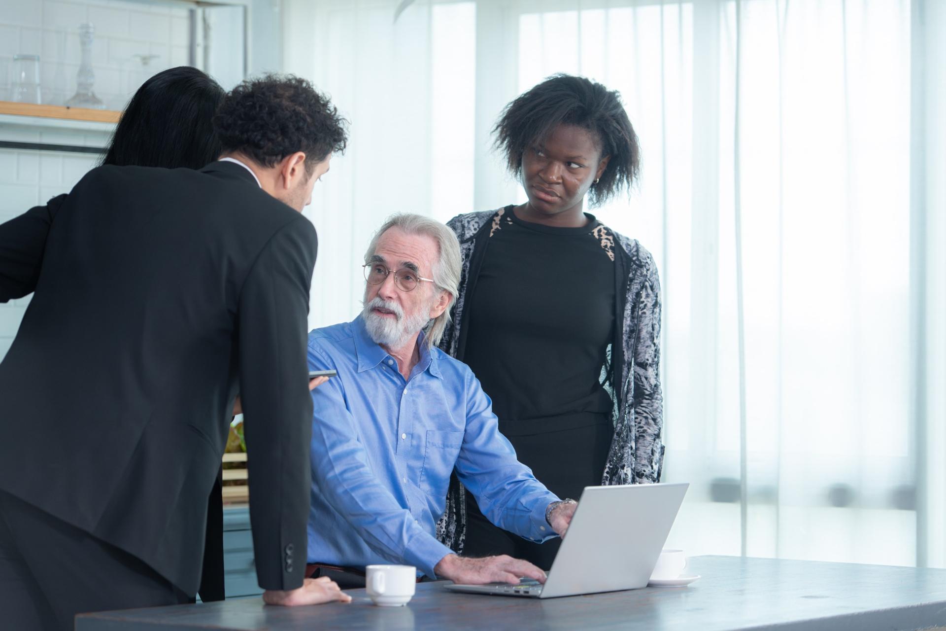 Concerned business team reviewing laptop data during an office meeting