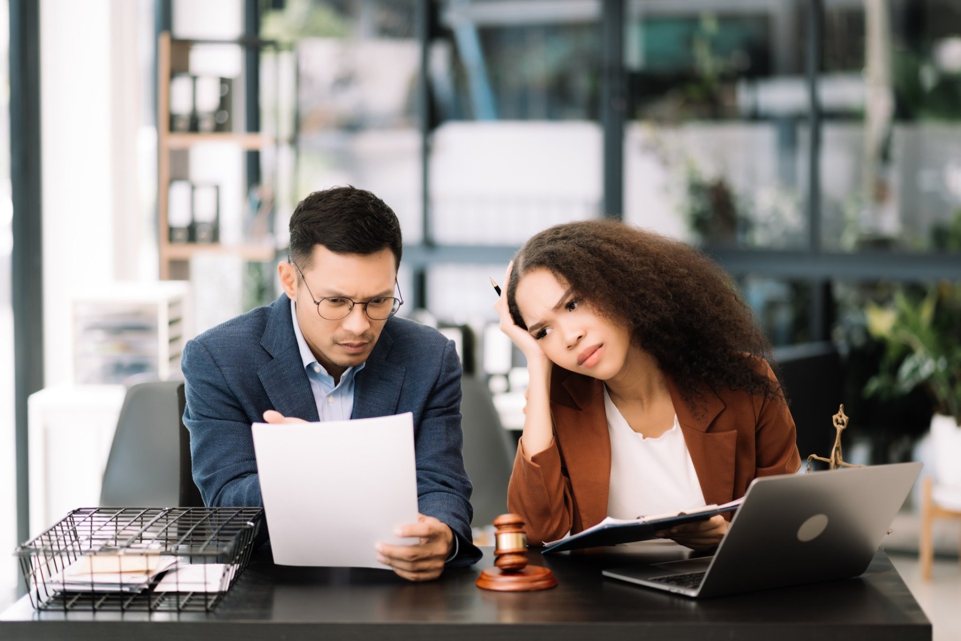Concerned legal team reviewing documents in a modern office