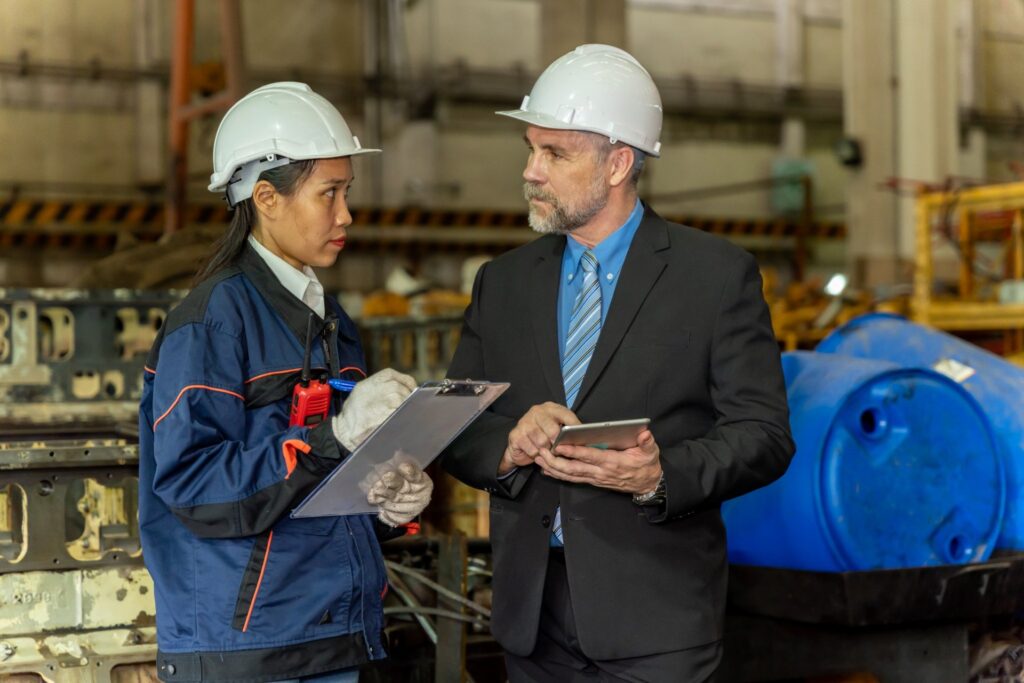 Engineer and manager discussing safety protocols in industrial warehouse