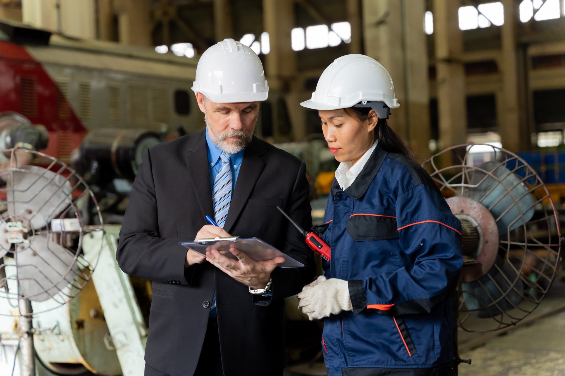Engineer and worker reviewing checklist at industrial facility